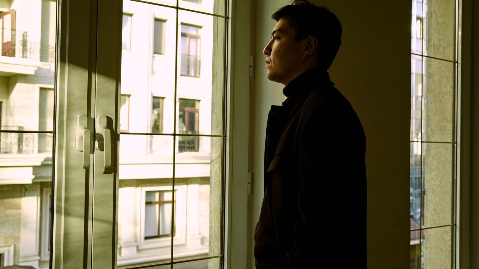 Personne pensive à la fenêtre, réflexion sur le sens du travail