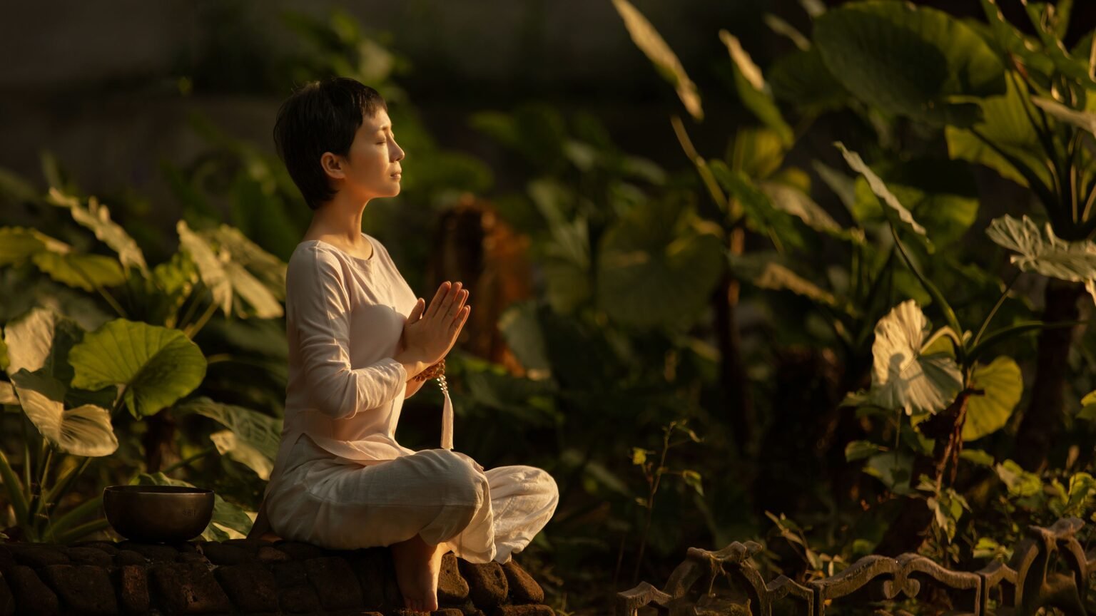 Femme en méditation dans un jardin serein, ashwagandha comme allié physiologique du calme stoïcien