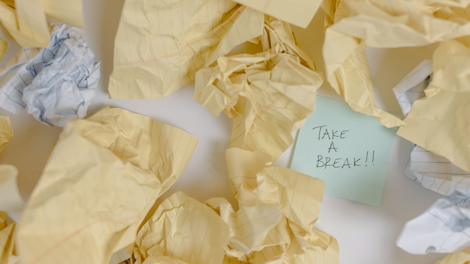 Bureau désordonné avec pile de dossiers, symbole de la procrastination